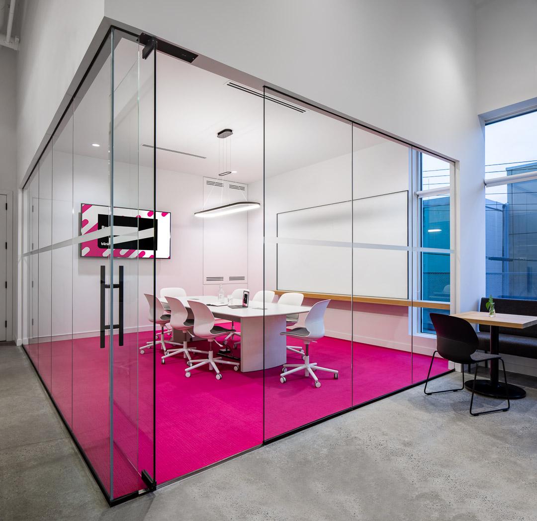 Glass-walled boardroom with tall windows and natural light